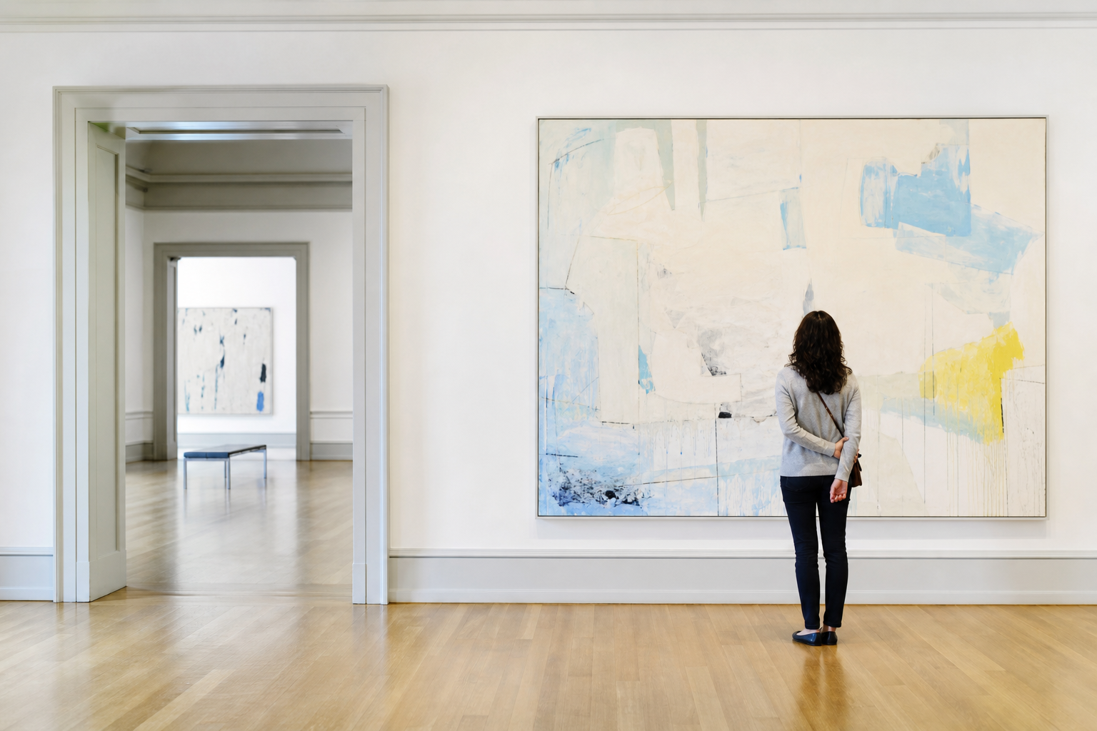 Bezoeker kijkt in een lichte museumzaal naar een groot abstract schilderij